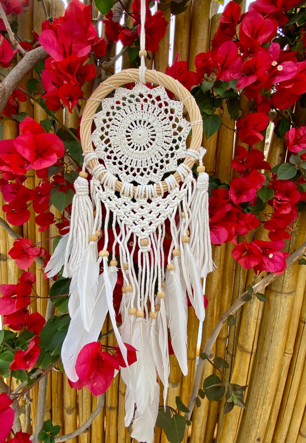 White dream catcher with feathers and rattan frame.