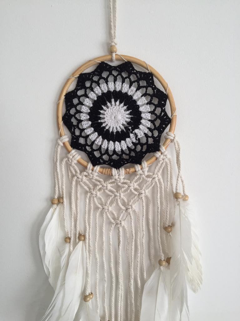 White and black dream catcher with feathers.